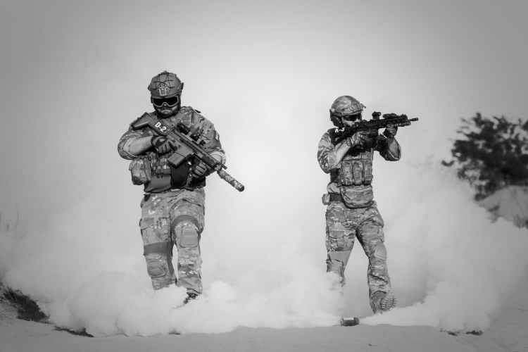 two men in military clothing with guns